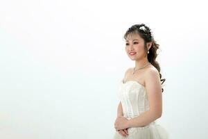 Young Asian woman in white dress hair done with crown on white background photo