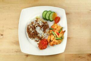 Turmeric Friend Chicken with vegetable white rice topped with dark sauce ayam goreng kunyit photo