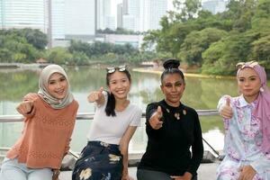 grupo de mujer malayo chino indio asiático malasio al aire libre verde parque lago naturaleza contento pulgares arriba gesto foto