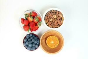 Blueberry Strawberry Herb Spice Almond Cashew Nut Mandarin Orange in bowl on white background photo