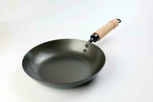 Cast metal not stick t wooden handle empty flat bottom frying sauce pan on white background photo