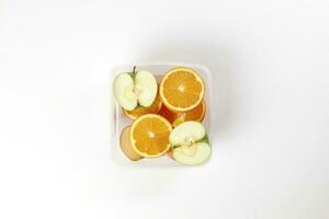 mix green red apple orange whole fruit cut slice half in plastic container on white background photo