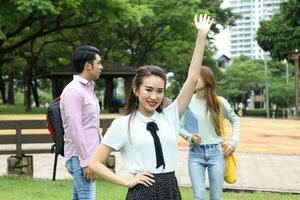 joven asiático malayo chino hombre mujer al aire libre parque libro archivo carpeta ordenador portátil computadora teléfono sentar estar estudiar mezclarse foto