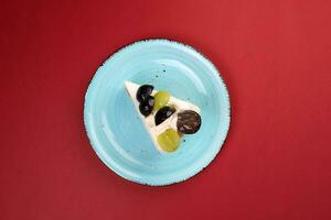 verde negro uva Fruta crema capa pastel Pastelería en rústico azul plato terminado rojo antecedentes foto