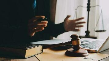 Justice and law concept.Male judge in a courtroom with the gavel, working with, computer and docking keyboard, eyeglasses, on table in morning light video