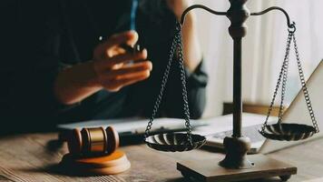 Justice and law concept.Male judge in a courtroom with the gavel, working with, computer and docking keyboard, eyeglasses, on table in morning light video
