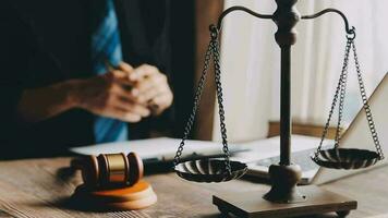 Justice and law concept.Male judge in a courtroom with the gavel, working with, computer and docking keyboard, eyeglasses, on table in morning light video