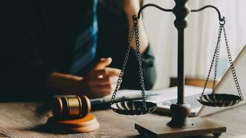 Justice and law concept.Male judge in a courtroom with the gavel, working with, computer and docking keyboard, eyeglasses, on table in morning light video