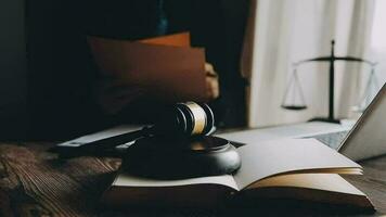 Justice and law concept.Male judge in a courtroom with the gavel, working with, computer and docking keyboard, eyeglasses, on table in morning light video