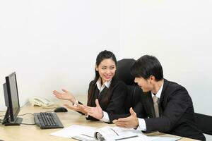 young Asian male female wearing suit sitting at office desk show point computer monitor happy success congratulate photo