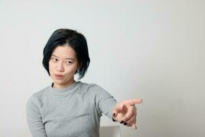 Young attractive Asian chinese malay woman pose face body expression mode emotion on white background angry annoyed point finger photo