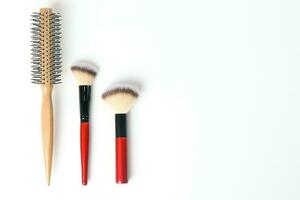 Red black makeup wooden hair brush comb beauty accessories on white background copy space border frame photo