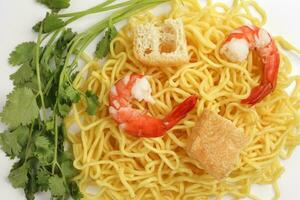 Fresh yellow egg noodle prawn tofu coriander leaf on whit background photo