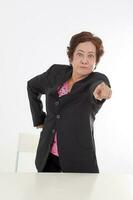 Elderly asian Chinese female on white background wearing black suit point at camera angry furious photo