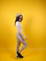 hermosa joven sur este asiático mujer rojo marco gafas de sol sombrero actitud Actuar caminar moverse adelante en amarillo naranja antecedentes foto