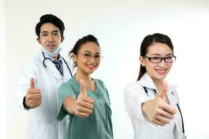 joven asiático malayo chino masculino hembra médico en blanco antecedentes pulgares arriba atención en mano dedo foto
