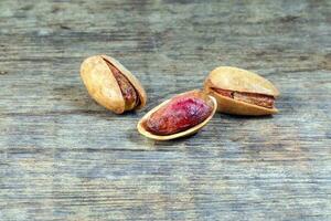 Pistachio nuts shell on rustic wood background photo