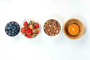 Blueberry Strawberry Herb Spice Almond Cashew Nut Mandarin Orange in bowl on white background photo