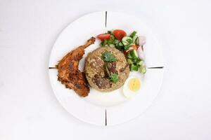 Beef Biryani Tehari with boiled egg coriander leaf garnish chicken curry pot roasted leg tomato cucumber onion chili coriander salad on white plate set over white background photo