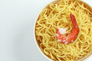 Fresh yellow egg noodle in bowl with prawn on whit background photo