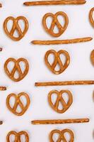 Pretzel cracker sticks laid in rows design angle straight on what background photo