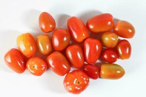 Fresh ripe small shiny red tomato on white background photo