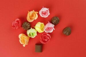 Chocolate truffle edible wafer paper rose flower cake decoration on red background photo