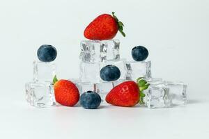 Strawberry blueberry berry read black ice cube on white background photo
