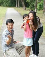 South East Asian young father mother daughter son parent boy girl child activity outdoors park photo