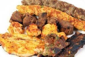 Mixed charcoal grilled platter chicken beef mutton goat meat shish kebab tawook middle east Arab photo