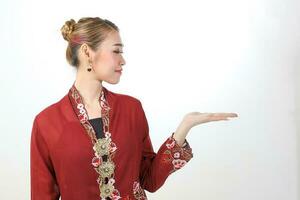 Asian woman traditional red maroon kebaya sharong on white background showing display hand palm photo