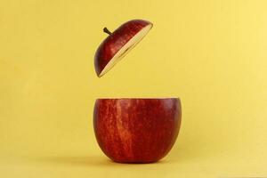 sano rojo cortar manzana flotante parte superior rebanada jugo bebida idea concepto en amarillo antecedentes foto