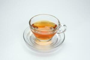 Clear licker tea in a transparent glass cup saucer on white background photo