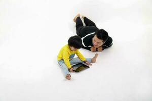 South East Asian father son child playing talking with tablet pc tab on white background photo