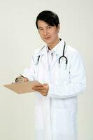 Young Asian male doctor wearing apron stethoscope holding writing on a clipboard photo