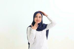 South east Asian Malay Woman headscarf facial expression stand happy think hand on head and chin photo