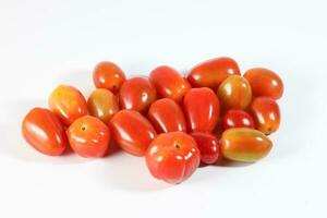 Fresh ripe small shiny red tomato on white background photo