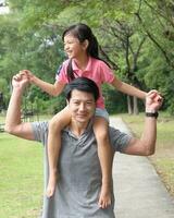 South East Asian young father mother daughter son parent boy girl child activity outdoors park photo