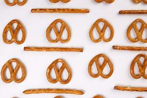 Pretzel cracker sticks laid in rows design angle straight on what background photo