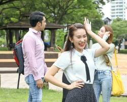 Young asian malay chinese man woman outdoor park walk stand study talk discuss point laptop file book backpack female look forward hello smile photo