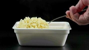 hand with fork taking, holding and putting back cooked instant noodles video