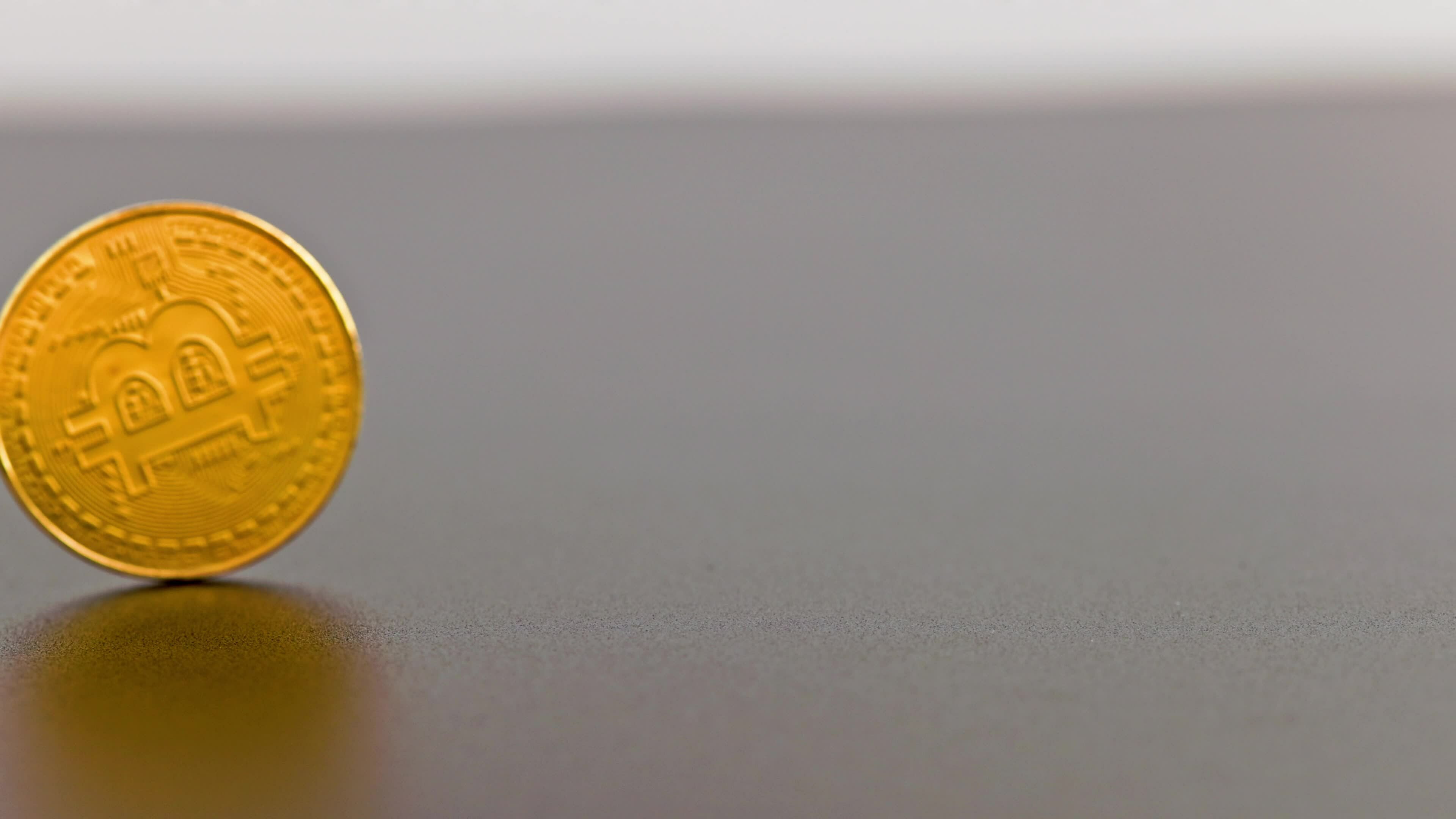 Bitcoin Coin Spinning On Gray Background Close Up With Slow Mo Bitcoin Coin Spinning On Gray Background Close Up With Slow Mo