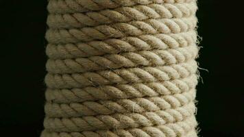 vertical coil of flax rope slowly rotating on black background video