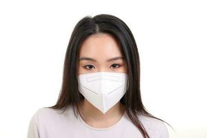 Beautiful young south east Asian woman wearing N95 anti virus bacterial surgical face mask on white background look forward photo
