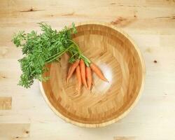 Small baby carrot with green leafs photo