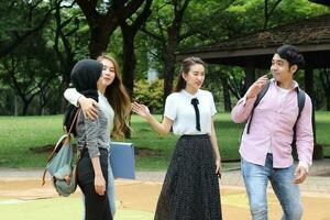 joven asiático malayo chino hombre mujer al aire libre parque libro archivo carpeta ordenador portátil computadora teléfono sentar estar estudiar mezclarse foto