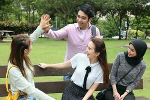 joven asiático malayo chino hombre mujer al aire libre parque libro archivo carpeta ordenador portátil computadora teléfono sentar estar estudiar mezclarse foto