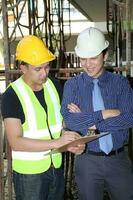 South East Asian young Malay Chinese man woman wearing safely helmet construction site work photo