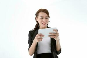 Southeast Asian young office business woman wearing suit holding reading using tablet tab on white studio background photo