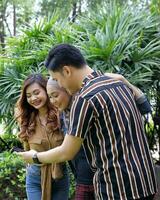 Young Asian Malay man woman outdoor green park walk talk discuss mingle photo